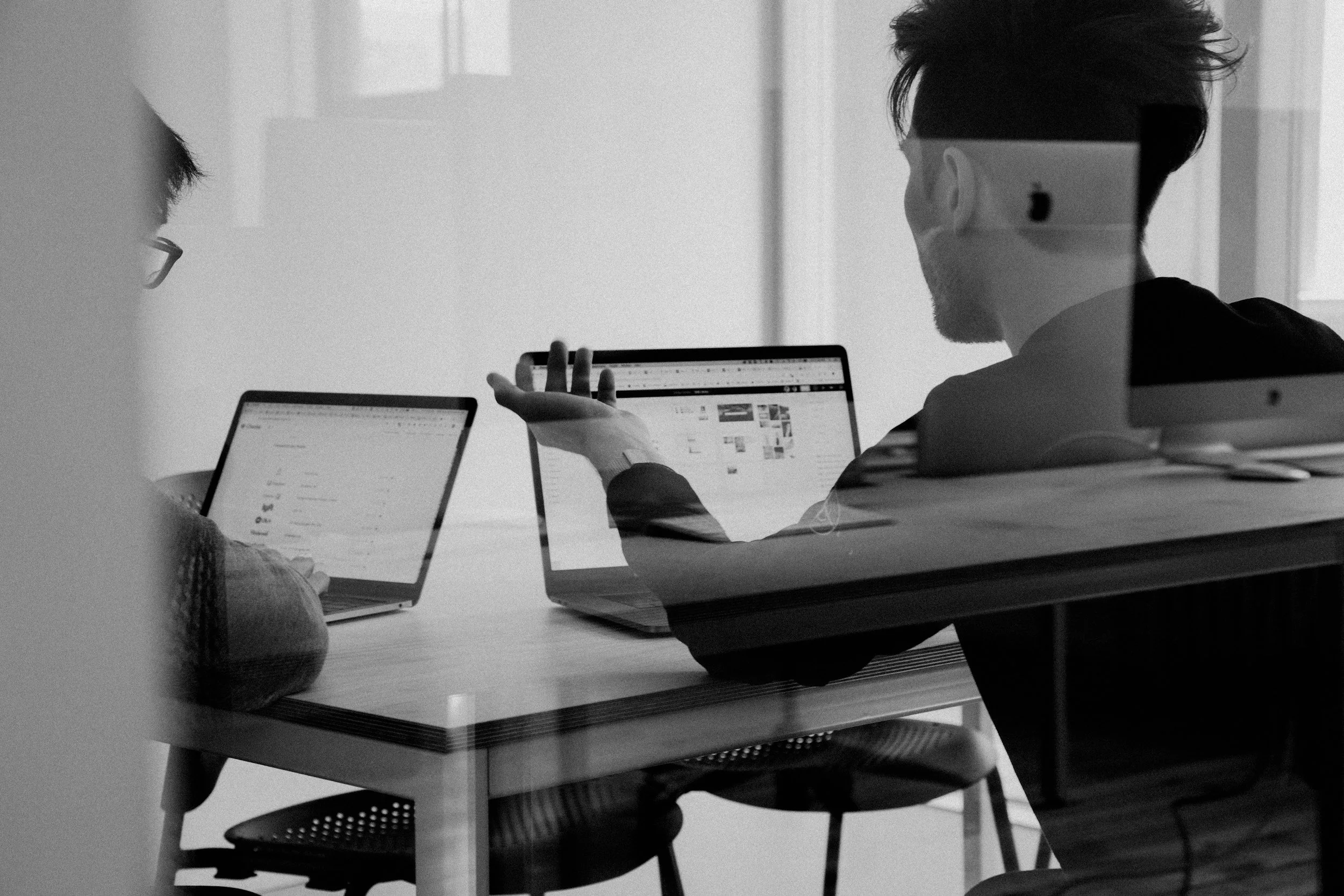 Colleagues reviewing information together on laptops