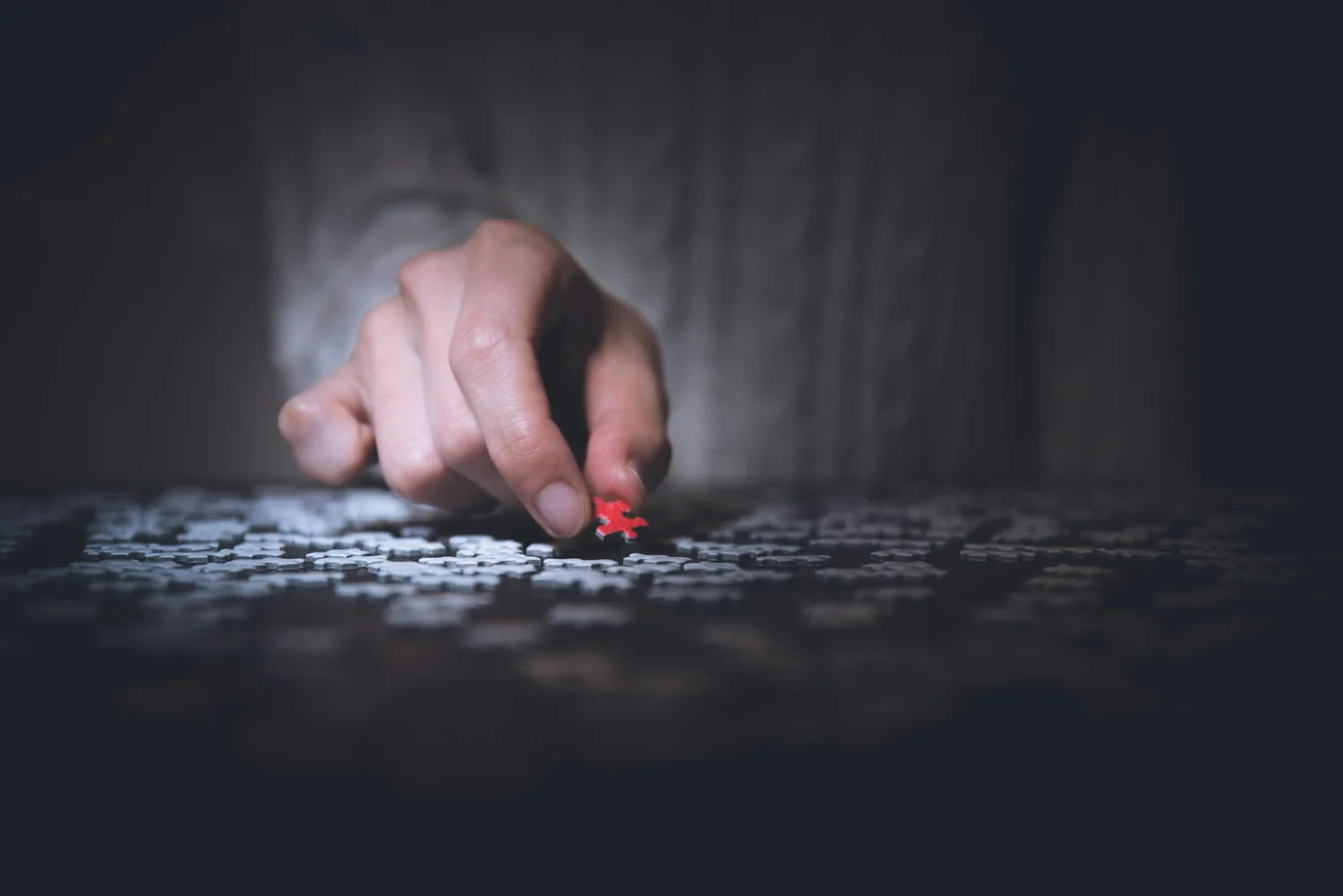 A hand placing a puzzle piece