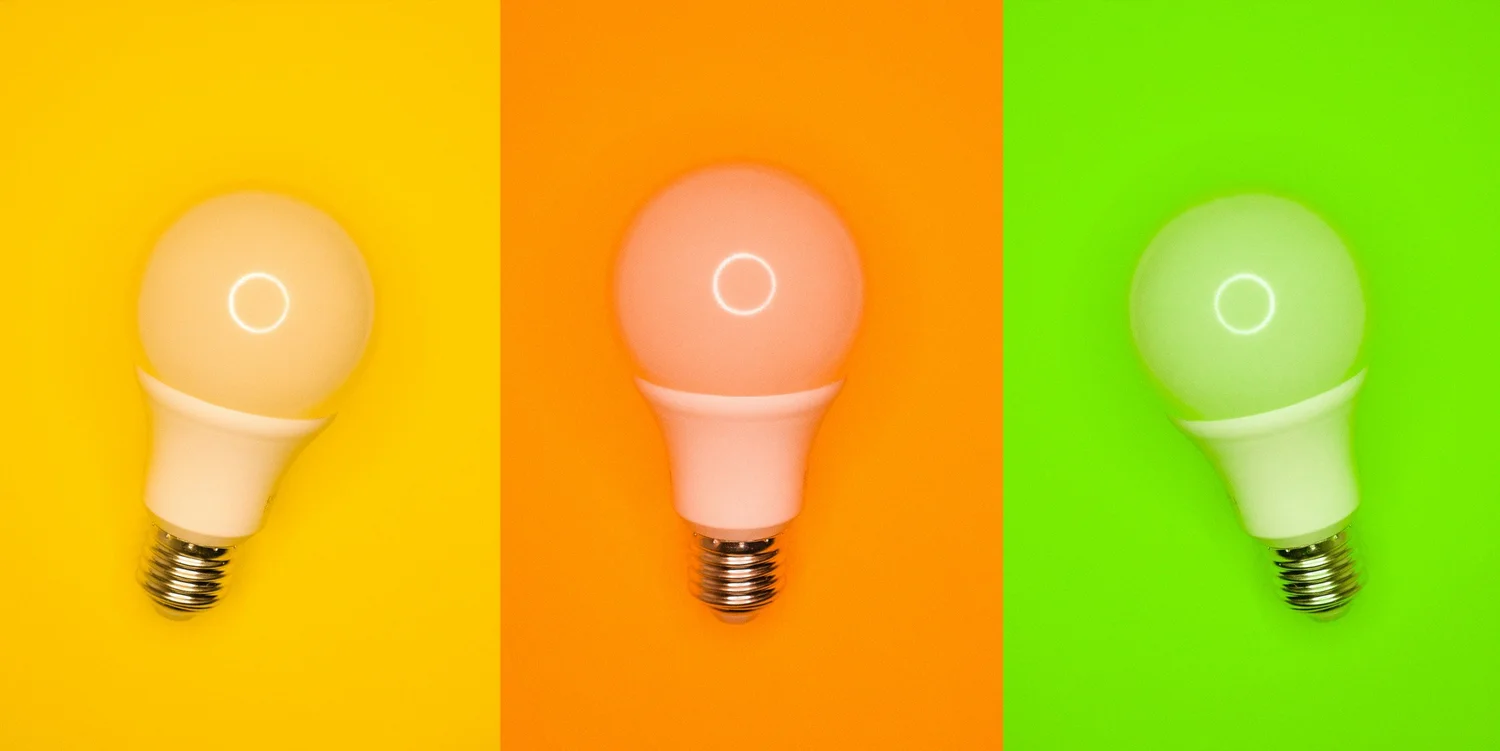 Three light bulbs against colourful backgrounds